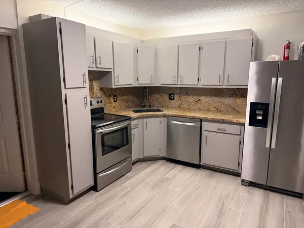 After: same kitchen with gray cabinets and new pulls.