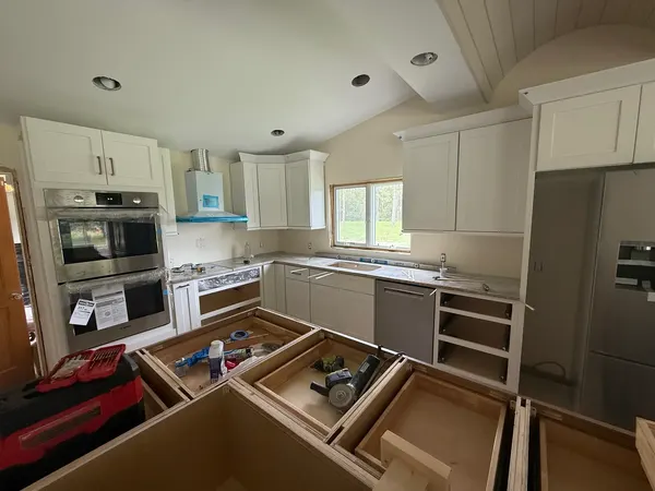 Shaker cabinets mid-install, island drawers still open.
