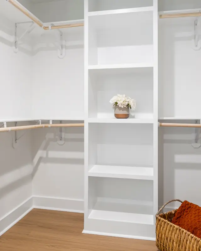 White walk-in closet with open shelving and hanging rods